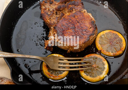 Schweinekotelett auf eisernen Pfanne mit Zitrone und Gewürze Gewürz angebraten Stockfoto