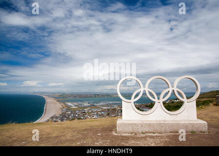 Blick über Portland, Chesil Beach & Weymouth Hafen durch die Olympischen Ringe Skulptur, Jurassic Coast, Dorset, England. Stockfoto