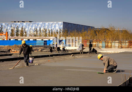 Im Bau befindliche Arbeitnehmer im olympischen Bereich, im Hintergrund der Olympische National Swimming Center, Beijing, China Stockfoto