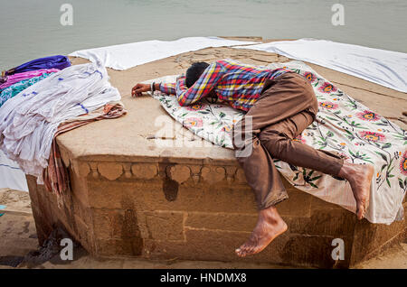 Laundryman ruhen Sie sich nach einem harten Arbeit, Dasaswamedh Ghat, im Fluss Ganges, Varanasi, Uttar Pradesh, Indien. Stockfoto