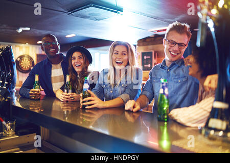 Die Getränke während der Kommunikation mit einander in der Bar mit Freunden lachen. Freunde und Spaß Konzept. Stockfoto