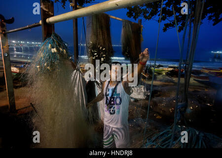 Fischer in den sehr frühen Morgenstunden am Strand der Copacabana Vorbereitung sein Netz für den Arbeitstag auf dem Meer, Rio De Janeiro, Brasilien Stockfoto