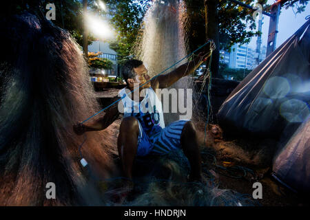 Fischer in den sehr frühen Morgenstunden am Strand der Copacabana Vorbereitung sein Netz für den Arbeitstag auf dem Meer, Rio De Janeiro, Brasilien Stockfoto