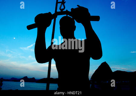 Silhouette eines Mannes Ausübung sehr früh am Morgen am Aterro do Flamengo, mit dem Zuckerhut im Hintergrund Stockfoto