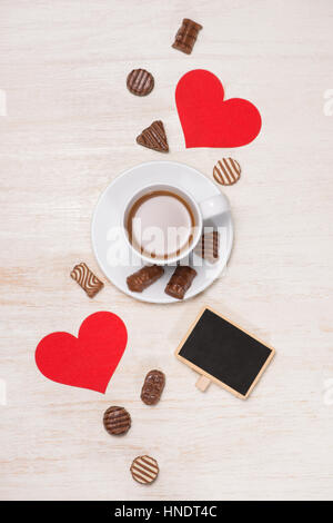 Valentinstag Hintergrund mit Schokokugeln, Kaffeetasse, rote Herzen und notebook Stockfoto