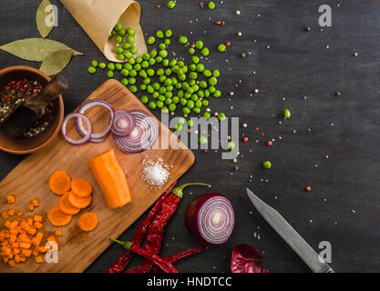 Kochen eine Mahlzeit mit frischem Gemüse. Die Zusammensetzung auf einem dunklen Hintergrund aus Holz. Ansicht von oben Platz für text Stockfoto