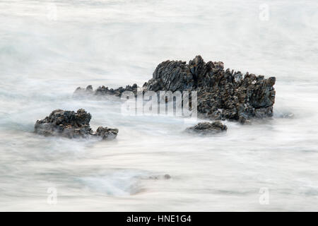 Felsen im Meer von Wellen getroffen Stockfoto