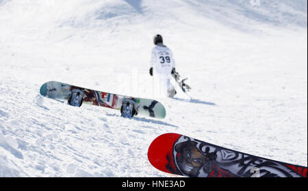 2 Snowboards auf dem Schnee. Ein snowboarder Wanderungen auf dem Berg im Hintergrund Stockfoto