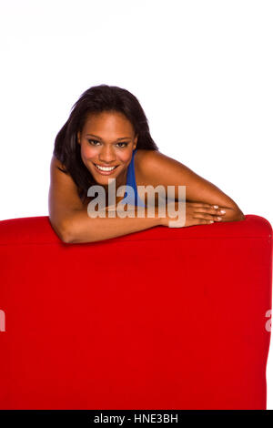 Afroamerikanische Frau in einem roten Stuhl sitzen. Stockfoto