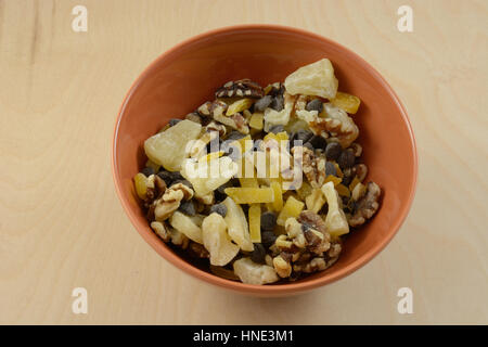 Trail Mix Snack von getrockneten Früchten und Nüssen und Schokolade-Chips in orange Schüssel Stockfoto