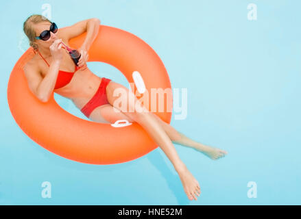 Model Release, Junge, Rutschelefanten Frau Mit Cocktail Im Schwimmbad - junge, attraktive Frau mit Cocktail im Schwimmbad Stockfoto