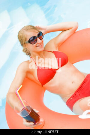 Model Release, Junge, Rutschelefanten Frau Mit Cocktail Im Schwimmbad - junge, attraktive Frau mit Cocktail im Schwimmbad Stockfoto