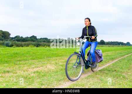 junge kolumbianische Frau Fahrradtouren auf Weg in der europäischen Natur Stockfoto