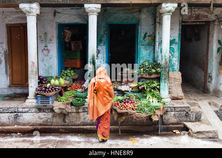 02.04.2017. Varanasi, Indien. Eine Frau kauft für Lebensmittel in einer Gasse in Varanasi, eine der heiligsten Städte Indiens. Bildnachweis: Rob Pinney Stockfoto