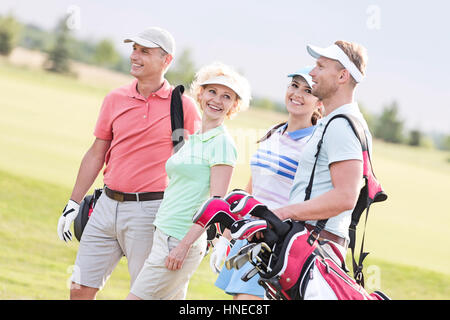 Glückliche Freunde zu Fuß am Golfplatz Stockfoto