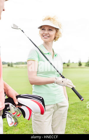 Glückliche Frau betrachten männlichen Freund am Golfplatz Stockfoto