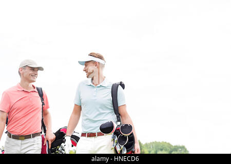 Glücklich männliche Golfer gegen Kommunikation klarer Himmel Stockfoto