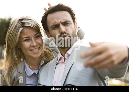 Spielerische Geschäft paar nehmen Selfie im Freien an sonnigen Tag Stockfoto