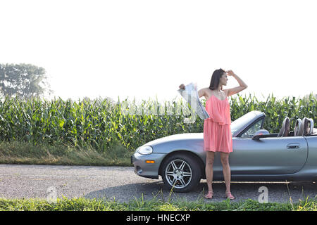 Voller Länge Frau Abschirmung Augen haltend Karte Cabrio Stockfoto