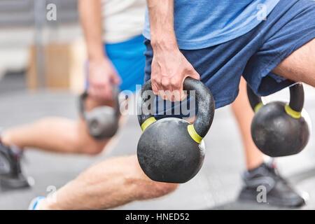 Bild von Männern heben Kettlebells bei Crossfit Gym beschnitten Stockfoto