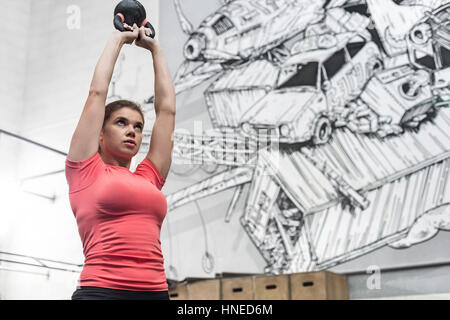 Niedrigen Winkel Ansicht aus engagierten Frauen heben Kettlebell in Crossfit gym Stockfoto