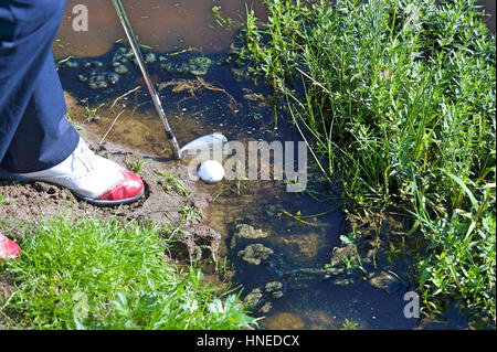 Mann, die Kugel aus dem Wasserhindernis Chippen Stockfoto