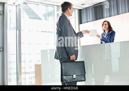 Geschäftsmann, die Empfangsdame in Office Dokument erhalten Stockfoto