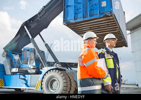 Arbeitnehmerinnen und Arbeitnehmer durch LKW im Frachthafen stehen Stockfoto