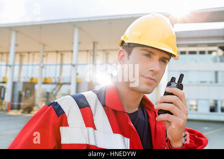 Männliche Arbeiter mit Walkie-talkie im Frachthafen Stockfoto