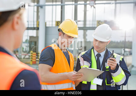 Arbeitnehmer über Zwischenablage im Frachthafen diskutieren Stockfoto