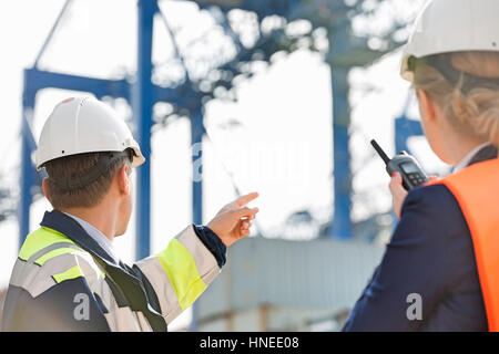 Männliche und weibliche Arbeitnehmer, die im Frachthafen Stockfoto