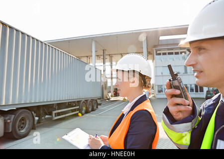 Männliche und weibliche Arbeitnehmer, die im Frachthafen Stockfoto