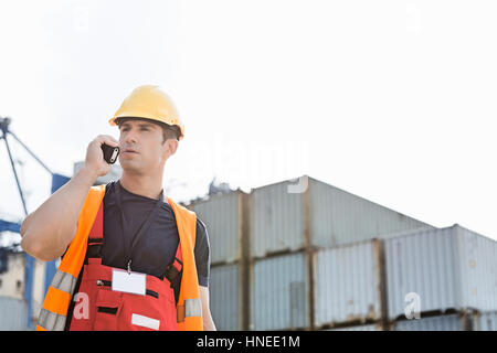 Männliche Arbeiter mit Walkie-talkie im Frachthafen Stockfoto