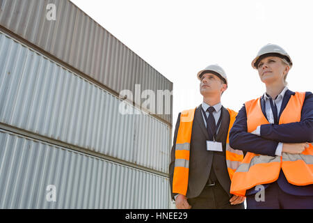 Niedrigen Winkel Ansicht von Arbeitnehmern gegen Frachtcontainer Stockfoto