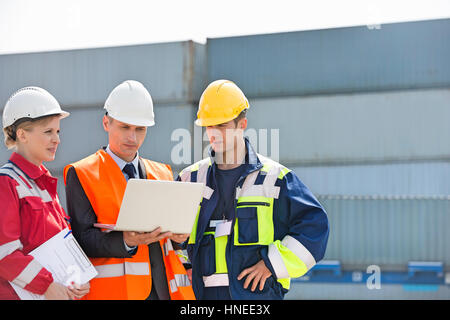 Arbeitnehmer über Laptop im Frachthafen diskutieren Stockfoto