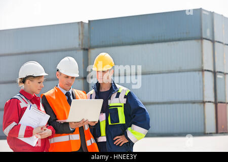 Arbeitnehmer über Laptop im Frachthafen diskutieren Stockfoto