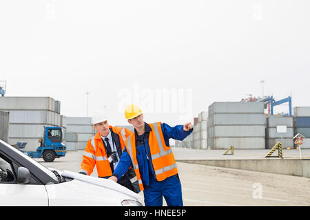 Arbeitnehmer über die Blaupause im Frachthafen diskutieren Stockfoto