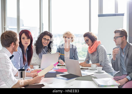 Diskutieren über Fotografien am Konferenztisch in Kreativbüro Geschäftskollegen Stockfoto