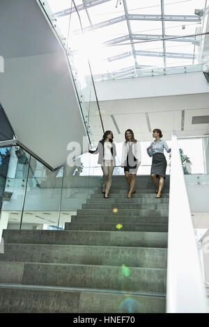 Glücklich Unternehmerinnen im Gespräch während der Bewegung nach unten Schritte im Büro Stockfoto