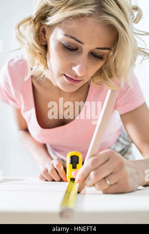 Schöne Frau Kennzeichnung Tisch mit Maßband Stockfoto