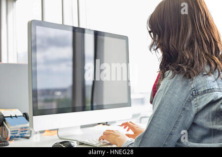 Rückansicht des Geschäftsfrau mit Desktop-Computer im Kreativbüro Stockfoto