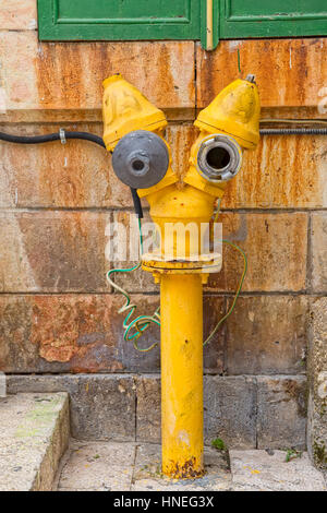 Lustige gelbe Hydrant auf einer Straße in der Altstadt von Jerusalem, Israel. Stockfoto