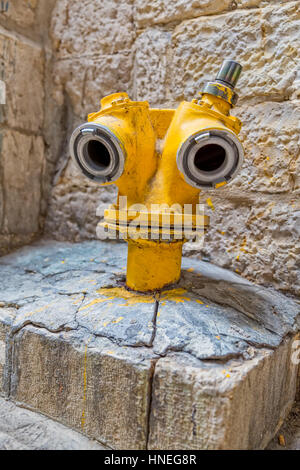 Lustige gelbe Hydrant auf einer Straße in der Altstadt von Jerusalem, Israel. Stockfoto