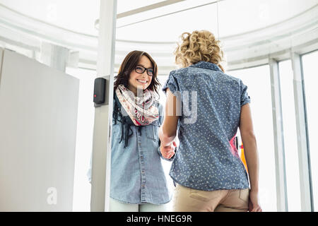 Glücklich Geschäftsfrauen Händeschütteln in Kreativbüro Stockfoto