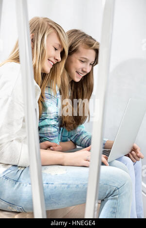 Schwestern mit Laptop auf Treppe Stockfoto