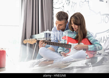 Vater Lehre Tochter, e-Gitarre zu Hause zu spielen Stockfoto