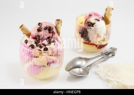 verschiedene Eissorten in einer Glasschale mit Syryp an der Spitze Stockfoto