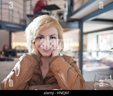 Porträt der schönen jungen Frau lächelnd in café Stockfoto