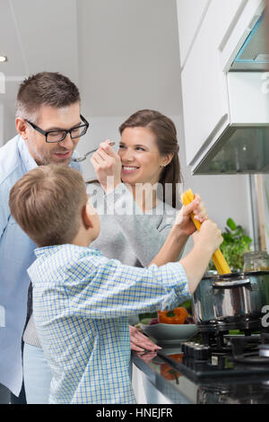 Glückliche Familie bereitet Spaghetti in Küche Stockfoto