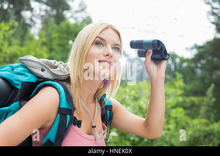 Junge weibliche Wanderer mit dem Fernglas im Wald Stockfoto